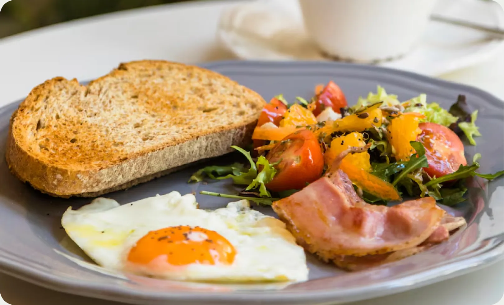 A balanced breakfast plate with eggs, whole-grain toast, and a fresh vegetable salad